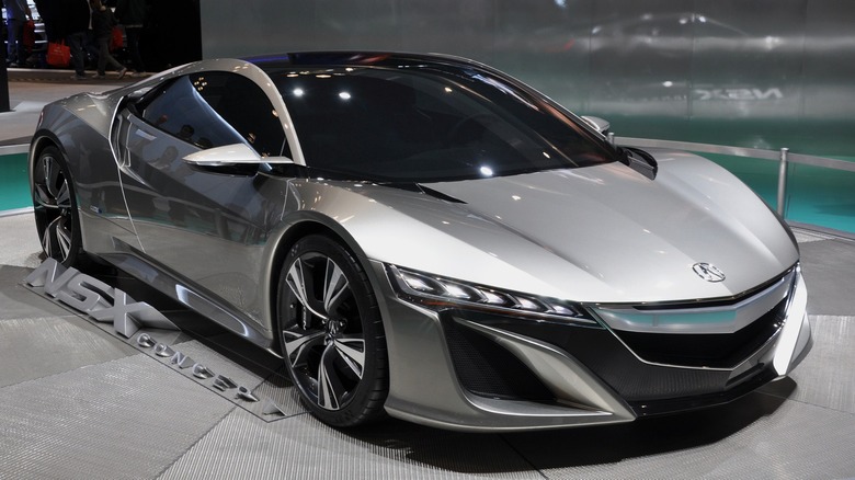A metallic Acura NSX on display in a Acura dealership showroom.