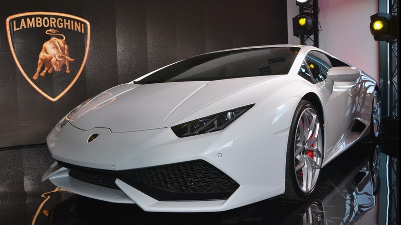 A White Lamborghini Huracán on display in a Lamborghini dealership showroom.