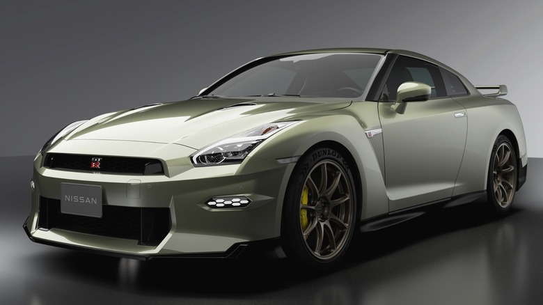 A metallic green Nissan GT-R sitting under studio lighting.