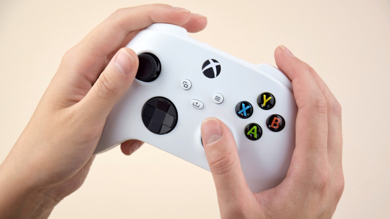 Hands holding a white Xbox controller