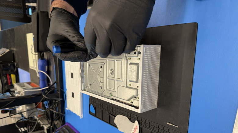 A technician working on an Xbox Series S console in a shop