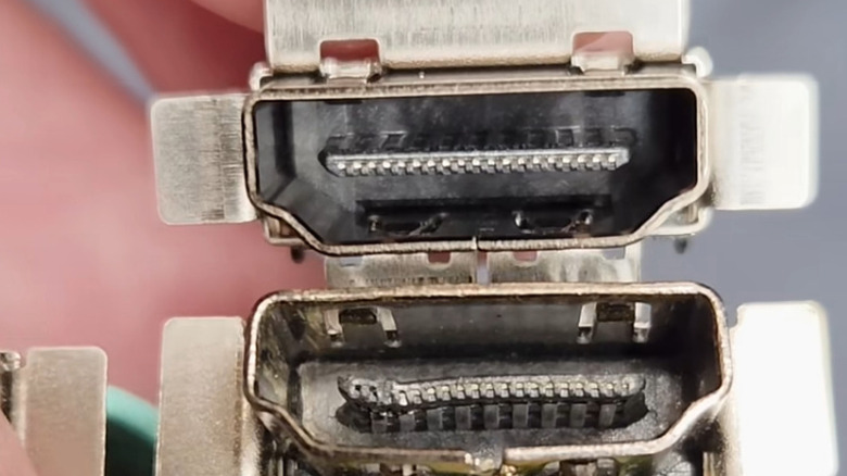 A close up of two HDMI ports for an Xbox Series X, with the bottom one being damaged and the top one being new