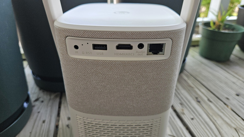 The Yaber T2 Plus Outdoor Projector showing off the ports on the back on a wood deck.