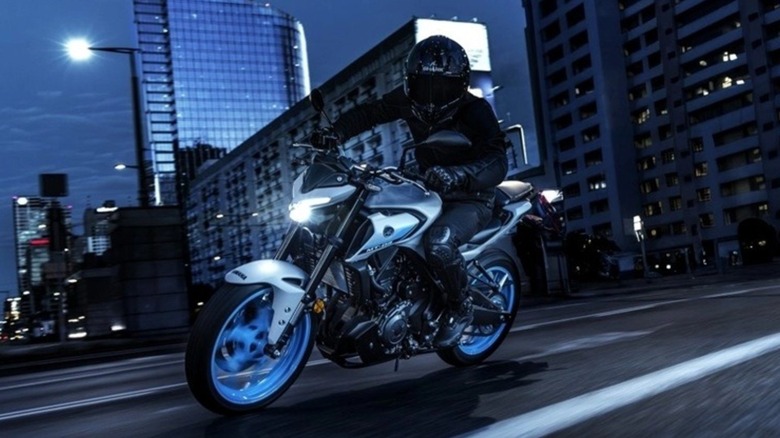 A rider aboard the Yamaha MT-03 cruising the streets at night.