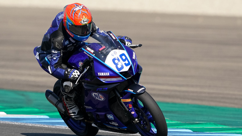 A person riding a Yamaha R3 bike on a race track