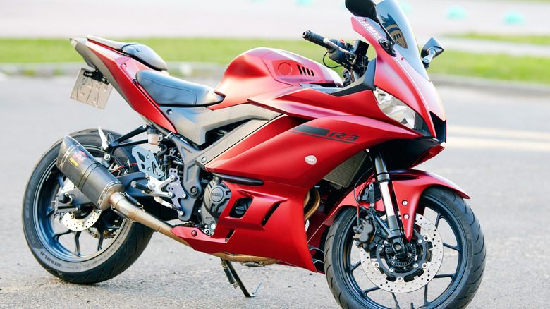 A sleek red Yamaha YZF-R3 parked in a lot