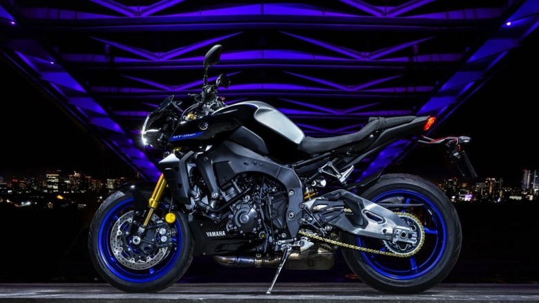 A black MT-10 SP with blue rims under a blue bride at night