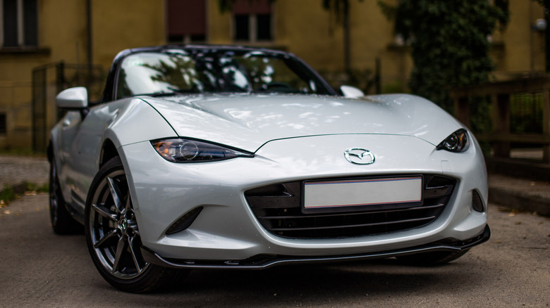 Silver Mazda Miata convertible parked on street