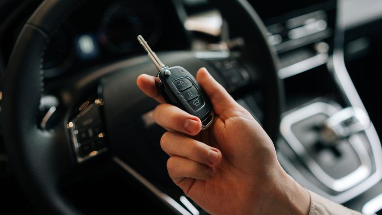 A person holding a car key.