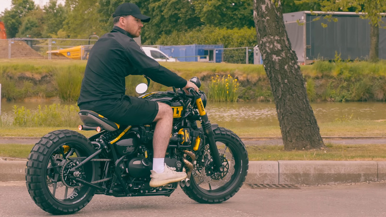 DeWalt motorcycle ridden by a man in shorts and a cap