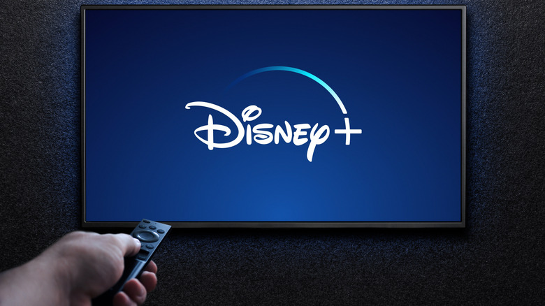Person using remote to control Disney+