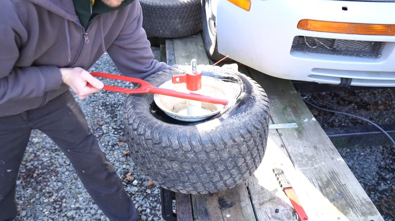 a person using the harbor freight pittsburgh mini-tire changer
