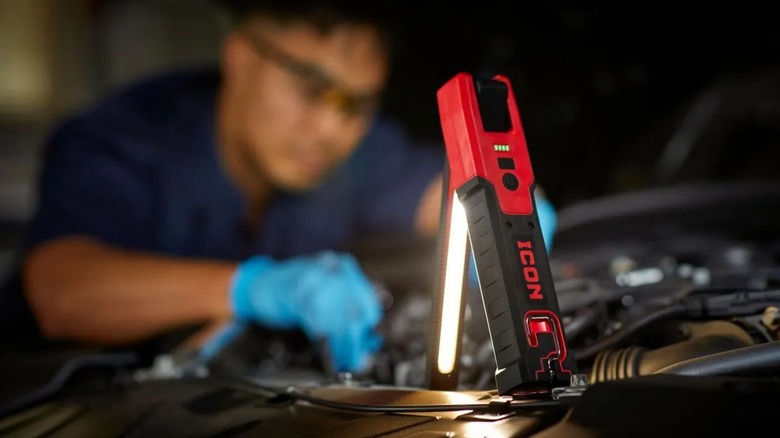 A man working on car with folding light