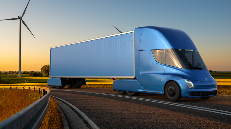 A rendered image of a blue Tesla Semi electric semi truck driving down a road at sunset.