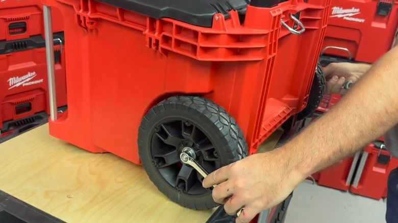 A person replacing Milwaukee Packout tool box wheels.