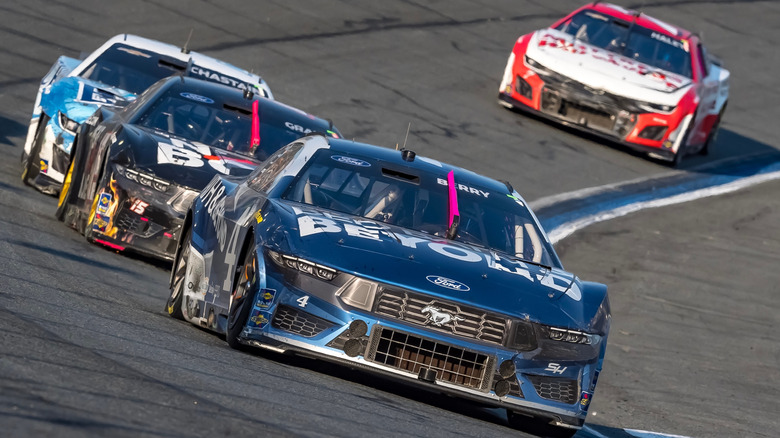 NASCAR stock cars turning on the oval of Charlotte Motor Speedway road course