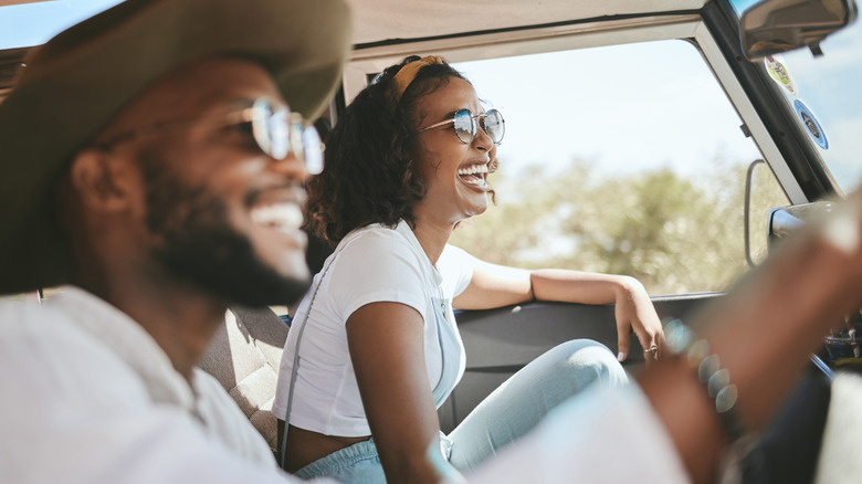 Person driving a car with passenger beside them.