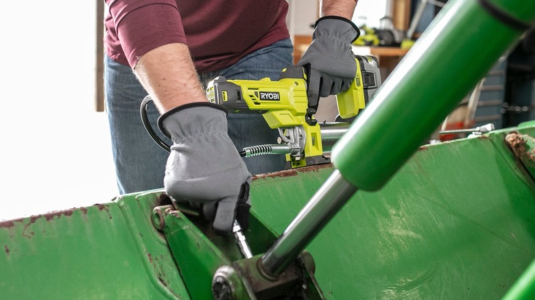Person using Ryobi Grease Gun