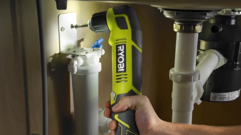 Person using Ryobi right angle drill on plumbing