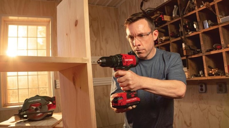 man using a Craftsman drill driver on wood