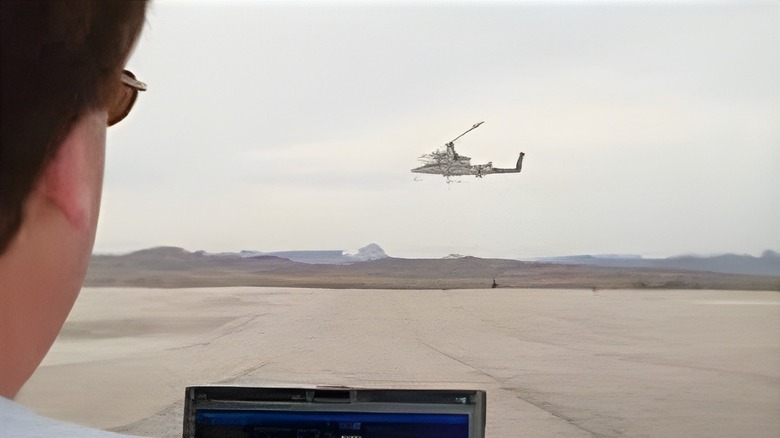 Pilot remotely testing unmanned helicopter using laptop