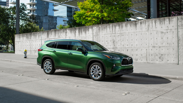 2025 Toyota Highlander on a city street, Cypress Green, front 3/4 view