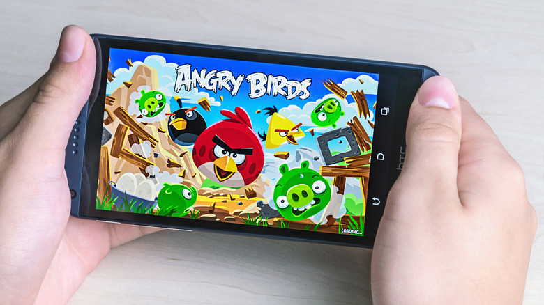 User playing "Angry Birds" on smartphone