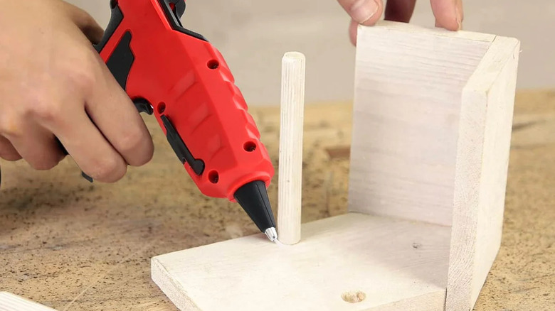 person using a Livowalny cordless hot glue gun to make a birdhouse