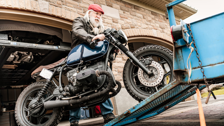 People loading bike onto trailer