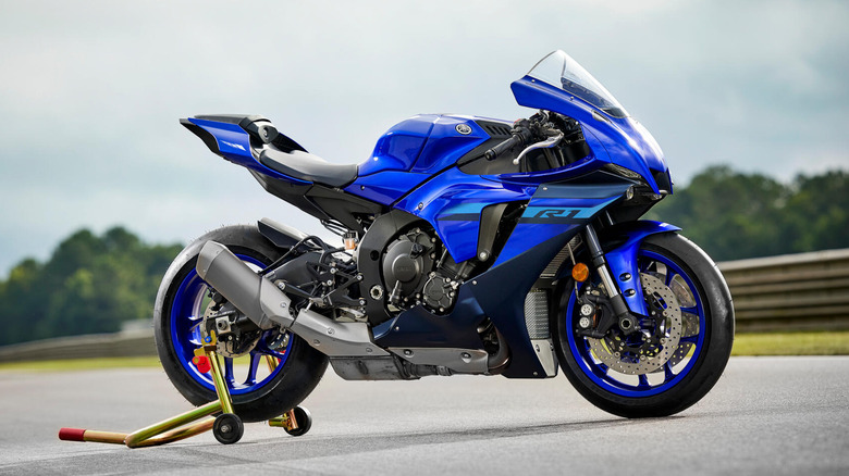 A side shot of a Yamaha YZF-R1 mounted on a motorbike stand on the side of a track