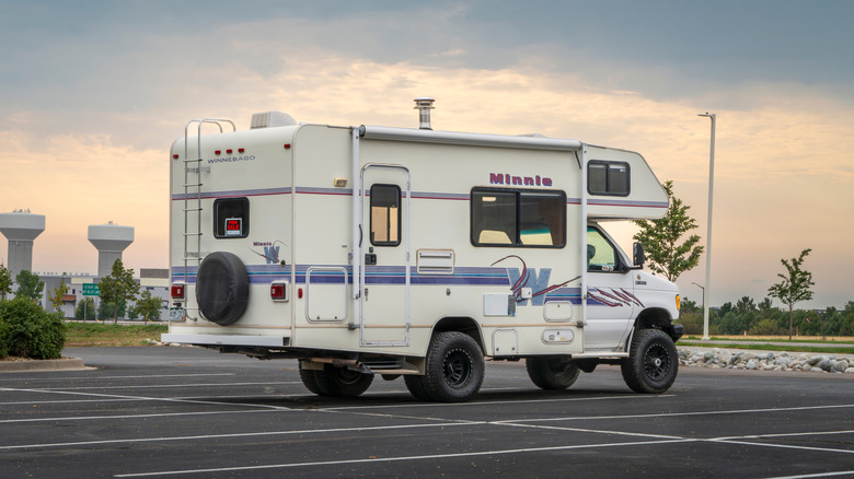 A small RV parked in an empty parking lot