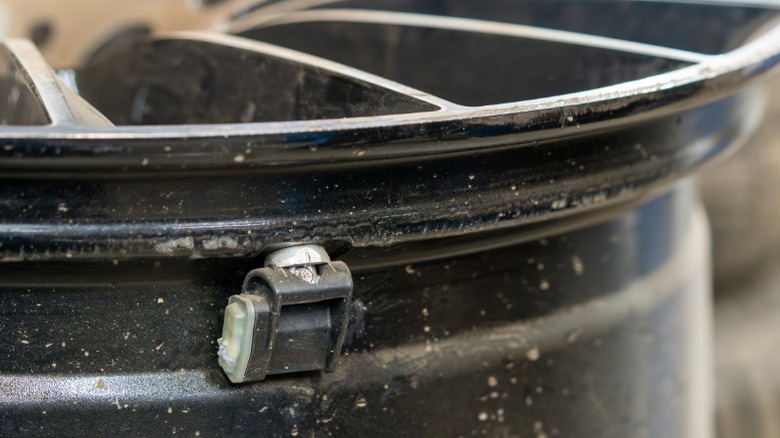 a closeup image of a tpms sensor mounted on a car's wheel