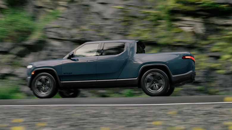 grey Rivian R1T in motion on mountain road