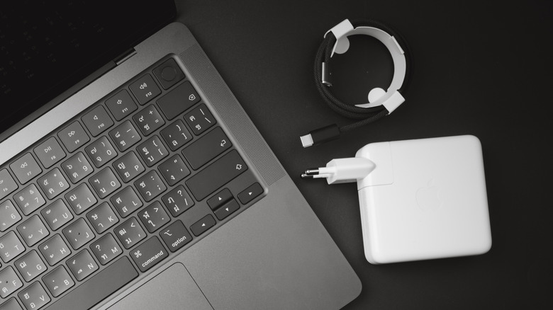 MacBook charger next to Macbook and cable