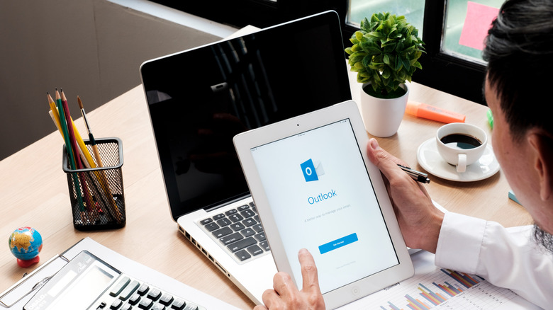 Man holding tablet with Outlook