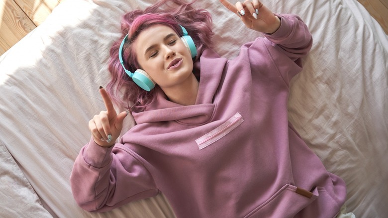 woman in bed listening to music
