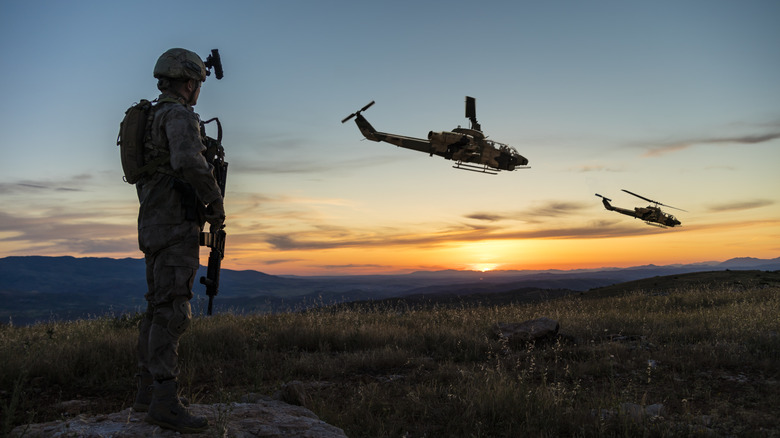 Soldier and military helicopters at sunrise 