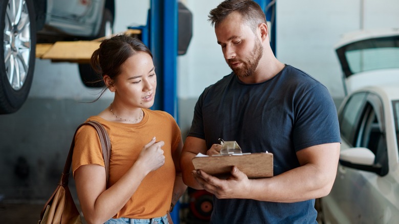 a mechanic breaking down a repair order with a customer