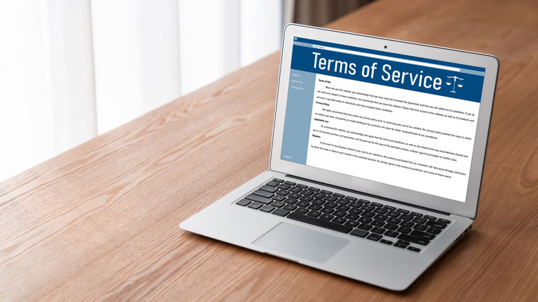 Laptop on a table. The text on the screen says "Terms of Service".