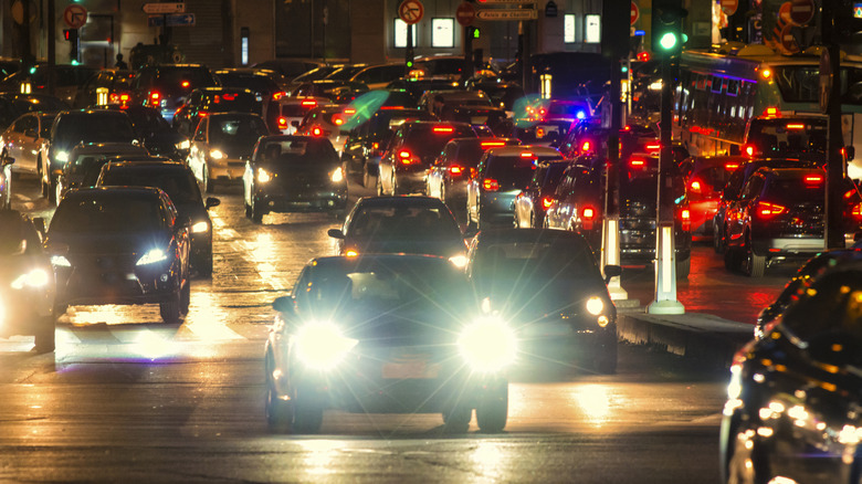 Audi fitted with LED lights shining noticeably brighter than other vehicles in busy traffic on two-lane main road at night