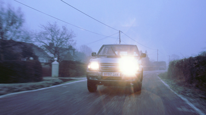 Older-model SUV fitted with aftermarket HID lights, front-view