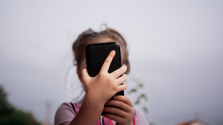 A young child using a smartphone.