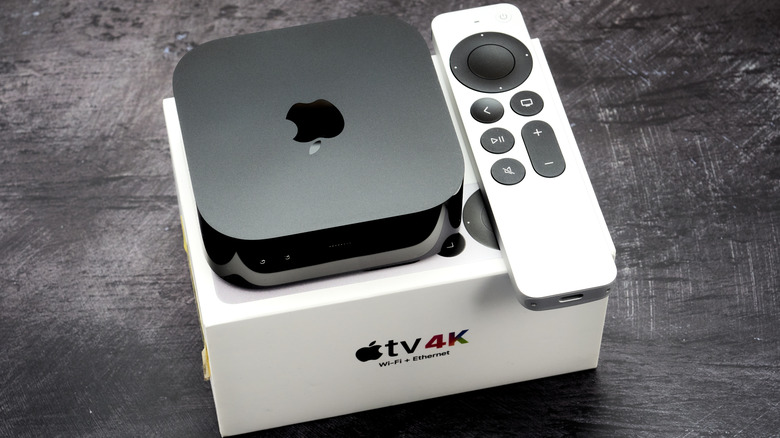 Apple TV device and remote sitting on top of a box