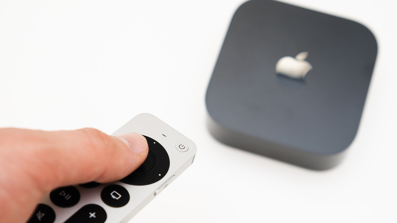 Person using remote control to work their Apple TV box
