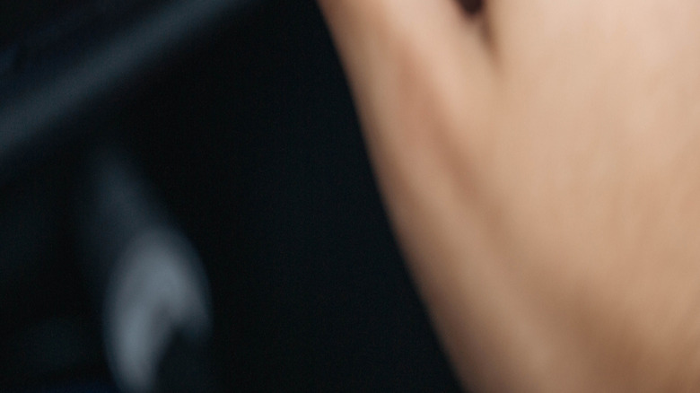 A person pushing the rear defrost button in a mid 90s Volkswagen