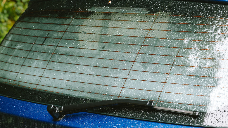 A foggy rear window of a hatchback, showing the heating lines up close