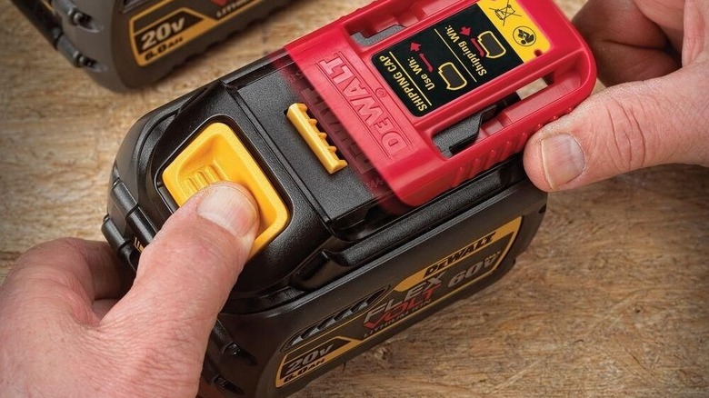 A person removing red cover on DeWalt Flexvolt battery
