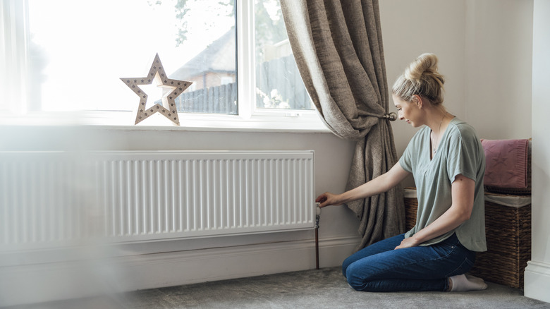 side view of a lady checking a heating system