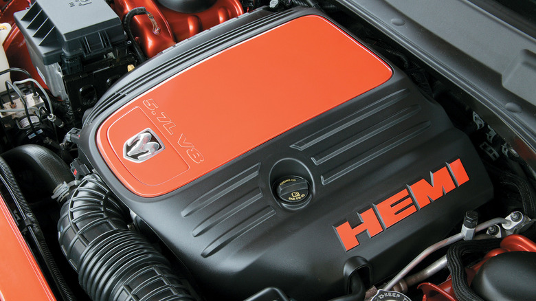 5.7L HEMI engine inside Dodge Charger, left-side view, bright red accents on the engine cover