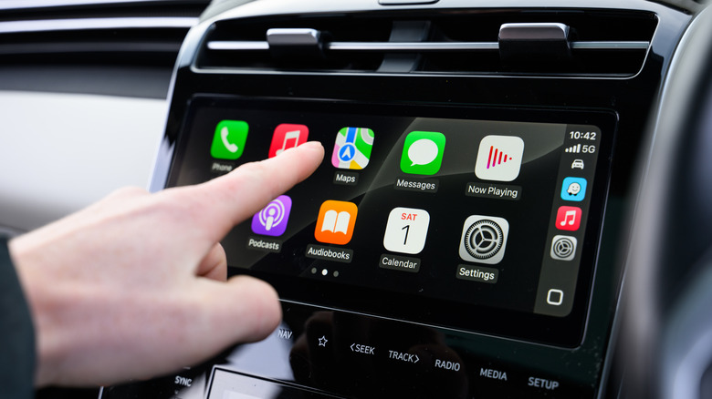 A person using Apple CarPlay on the infotainment system